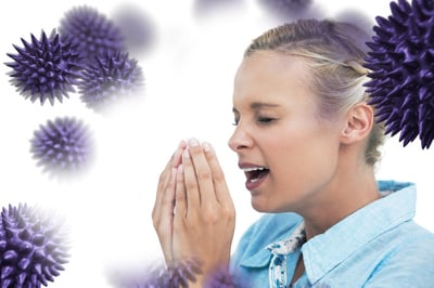 woman sneezing with hands in front of her face against virus